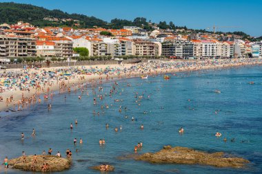 Sanjenjo, İspanya, 15 Ağustos 2024: Silgar Plajı güneşli bir günde Galiçya 'nın Ria de Pontevedra kentinde turistlerle dolu