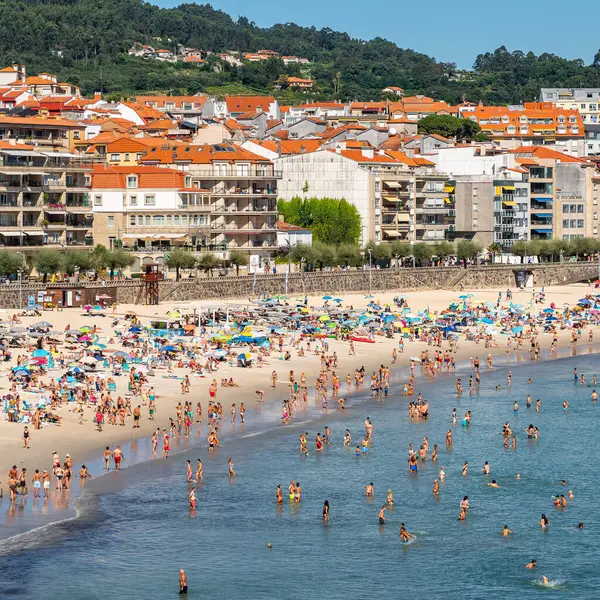 Sanjenjo, İspanya, 15 Ağustos 2024: Silgar Plajı güneşli bir günde Galiçya 'nın Ria de Pontevedra kentinde turistlerle dolu