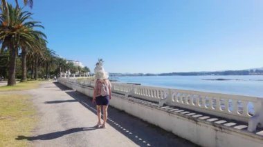 Güneşli bir günde Galiçya 'da La Toja adasında gezinen turist kadın.
