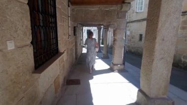 Galiçya 'nın eski Pontevedra kentinin dar sokaklarında gezinen turist kadın.