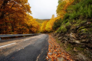 Yol yapmak için büyük kayaların yanından geçen dağ yolu, Somosierra, Madrid