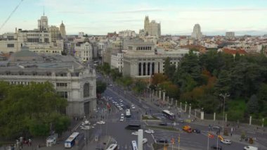 Plaza de Cibeles, yeni bir günün şafağında İspanya 'nın Madrid şehrinde çevre sokaklardan geçen araçlarla.