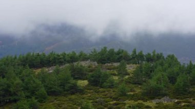 Tepelerin tepesinde bulut oluşumu rüzgarla hareket etti. Somosierra, Segovia.