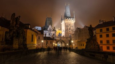 Antik ortaçağ kulesi geceleri Charles Köprüsü 'nün girişinde ve Prag, Çek sisli