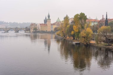 Charles Köprüsü ve ortaçağ binalarına bakan sisli bir günde Vltava Nehri, Prag