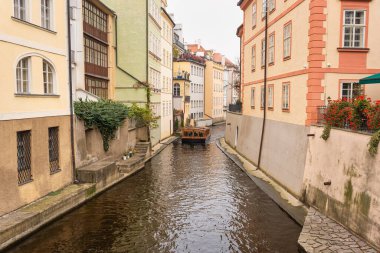 Prag şehrinin binaları arasında Vltava Nehri 'nde dolaşan küçük bir turist teknesi.