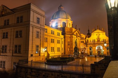 Prag 'ın anıtsal kentinin binaları gece karlı büyülü bir atmosferde aydınlandı.