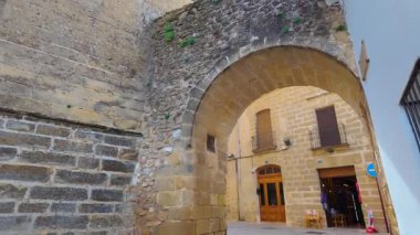 Baeza, Jaen anıtsal şehrinin sokaklarındaki kilise kulesi ve taş kemer.
