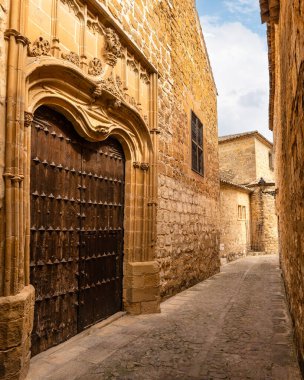 Büyük ahşap kapıları ve cephelerinde süsler olan etkileyici ortaçağ evleri, Baeza.
