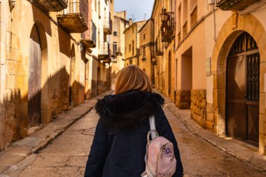 Ortaçağ Calaceite sokaklarında gezinen turist kadın Teruel, Aragon 'da
