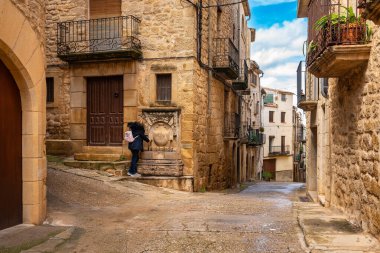 Ortaçağ 'ın Calaceite, Matarrana, Teruel kentindeki bir çeşmeden tatlı su içen turist kadın