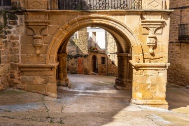 Calaceite, Teruel 'deki yağmurdan korunan caddelerde dolaşmak için ortaçağ binalarındaki taş kemerler.