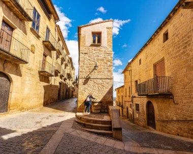 Calaceite, Teruel 'in ortaçağ sokaklarında halka açık bir çeşmeden tatlı su içen turist kadın