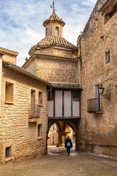 Ortaçağ şehri Calaceite, Teruel, Aragon 'un dar sokaklarında gezinen turist kadın.