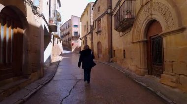Calaceite, Teruel, Aragon 'un güzel ortaçağ sokaklarında yürüyen turist kadın.