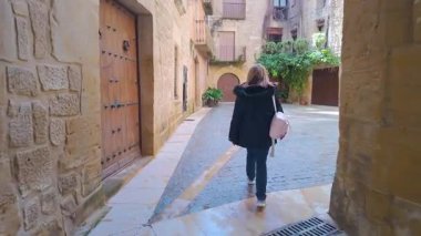 Teruel, Calaceite, Aragon köyünün ortaçağ mimarisinden keyif alan turist kadın.
