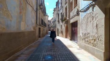 Calaceite, Teruel, Aragon 'un güzel ortaçağ sokaklarında yürüyen turist kadın.
