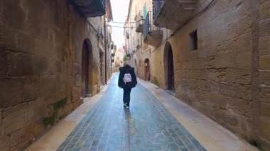 Calaceite, Teruel, Aragon 'un güzel ortaçağ sokaklarında yürüyen turist kadın.