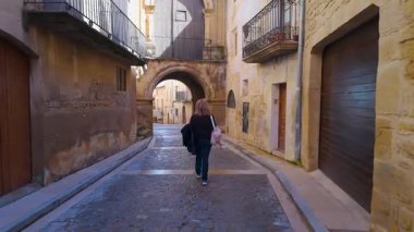 Orta çağ köyü Calaceite, Teruel, Aragon 'da dar sokaklarda gezen kadın turist.