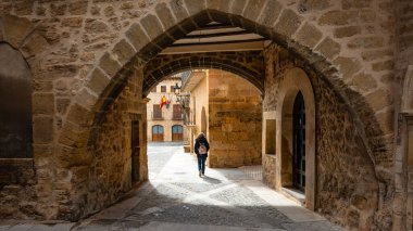 Sırtı dönük kadın turist Kretas, Matarrana, Teruel 'in pitoresk caddelerinde yürüyor.