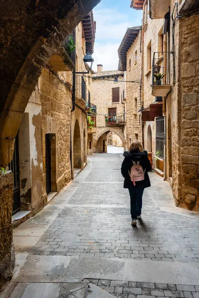 Sırtı dönük kadın turist Kretas, Matarrana, Teruel 'in pitoresk caddelerinde yürüyor.