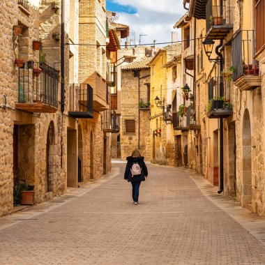 Arkadan gelen kadın turist, ortaçağ Kretas kasabası Teruel Matarrana 'nın sokaklarında geziniyor.