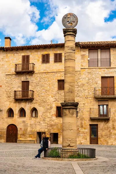 Kretas, Teruel, Aragon köyünün ana meydanında dinlenen kadın turist.