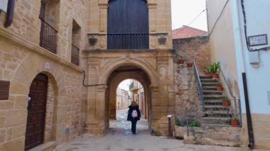Arkadan gelen kadın turist, ortaçağ Kretas kasabası Teruel Matarrana 'nın sokaklarında geziniyor.
