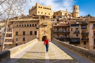 Valderrobres kasabasına giden ortaçağ taş köprüsünü geçen turist kadın, Teruel