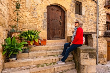 Ortaçağ evlerinde dinlenen turist kadın Valderrobres köyünün manzarasının keyfini çıkarıyor, Teruel..