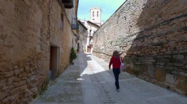 Ortaçağ Valderrobres köyünün dar sokaklarında yürüyen turist kadın, Matarrana