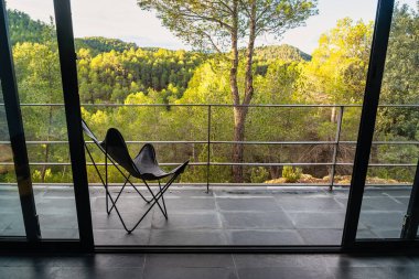 Şafakta ormanın muhteşem manzarasının tadını çıkarmak için sandalyeli teras.