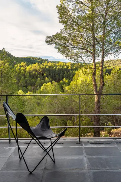 Şafakta ormanın muhteşem manzarasının tadını çıkarmak için sandalyeli teras.