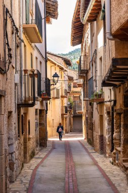 Turist kadın Beceite, Teruel 'deki eski taş evlerin keyfini çıkarıyor.