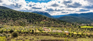 Matarrana bölgesindeki Penarroya de Tastavins kasabasını çevreleyen dağ manzarasının panoramik görüntüsü