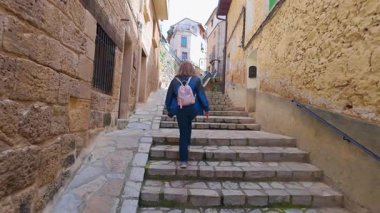 Turist kadın, güzel Beceite, Teruel, Aragon köyünün sarp sokaklarında geziniyor.