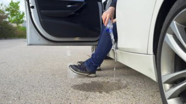 Adam arabada oturup yola bir şişe su atıyor ve çevreyi kirletiyor.