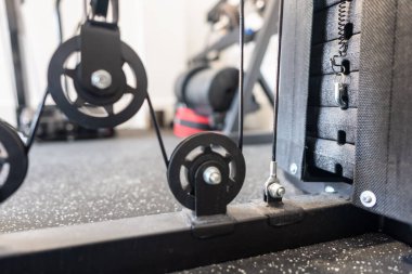 Güç ve kasları geliştirmek için makara ve ağırlık diskleri olan ağırlık makinesi.