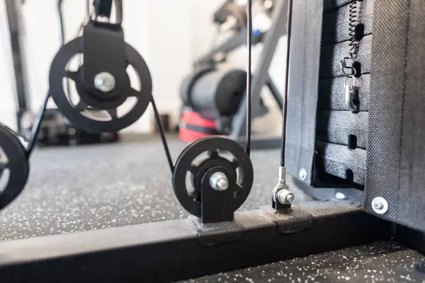 Güç ve kasları geliştirmek için makara ve ağırlık diskleri olan ağırlık makinesi.