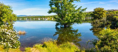 Güneşli bir günde güzel bir baharın açtığı Atazar rezervuarının panoramik manzarası, Madrid