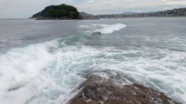 San Sebastian tatil köyündeki La Concha Körfezi 'nde deniz dalgaları çarpıyor..