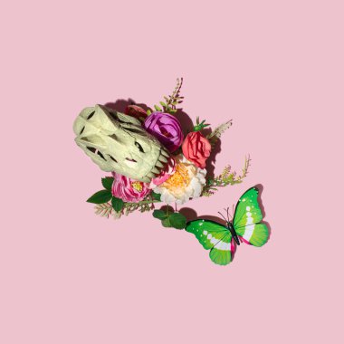 Dinozor kafatası, etobur dişler ve bir demet renkli çiçek, yaratıcı gotik tarz, pastel pembe arka plana karşı doğal düzen. 