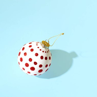 Kırmızı noktalı beyaz Noel mücevheri, minimum yaratıcı kış tatili buzlu mavi arka plana karşı ilham verici bir düzen.. 