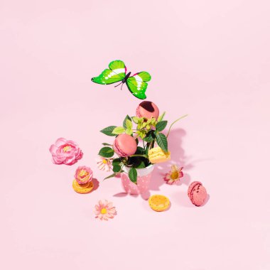 Pembe arka planda badem kurabiyelerinin, kelebeklerin ve çiçeklerin güzel bahar kompozisyonu