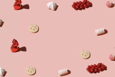 Kirazlar, şekerler, kırmızı meyveler, lolipoplar, yaratıcı fotokopi alanı, pastel pembe arka plan..