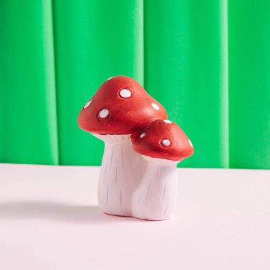 Şirin mantarlar, seramik dekorasyon, canlı yeşil pelüş örtülü arka plan..