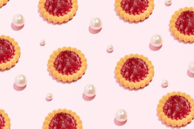 Reçelli kurabiye ve inci boncuklar, yaratıcı yemek kalıpları, pastel pembe arka plan..