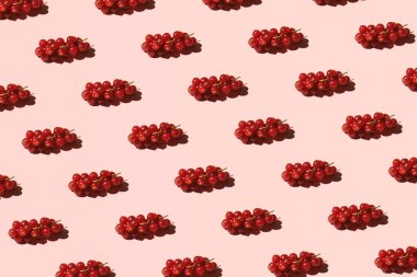 Frenk üzümü, taze kırmızı çilek, yaratıcı meyve deseni, pastel pembe arka plan..