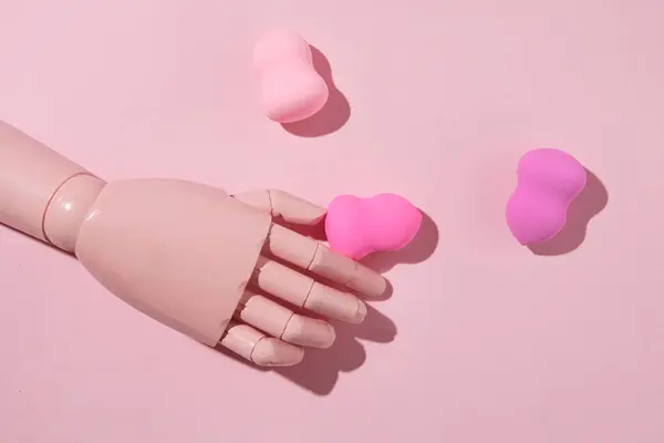 Mannequin hand and makeup sponges, pink shades, creative beauty care concept. Girly style.