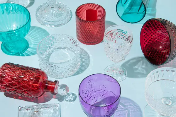 Colored crystal glassware, creative aesthetic drink party background.